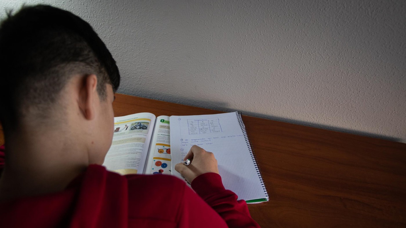 Un niño realiza sus deberes en su habitación durante el confinamiento
