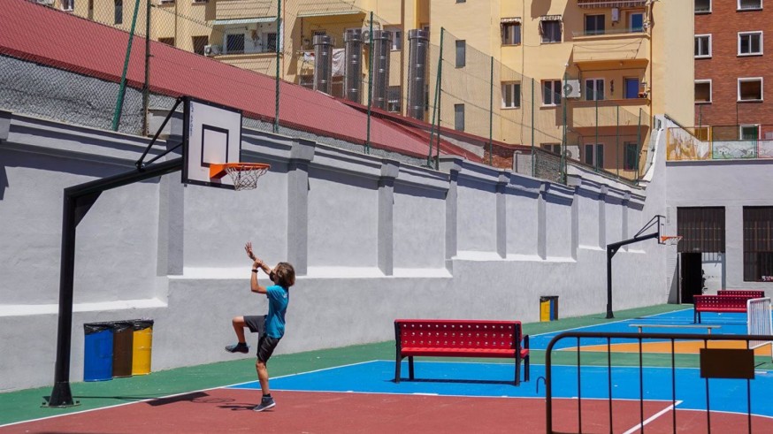 Un niño jugando al baloncesto en el patio con mascarilla. A. Pérez Meca - Europa Press
