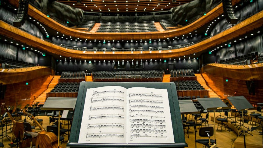 Teatro, partitura en atril e instrumentos de orquesta
