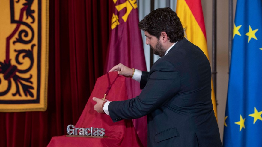 López Miras coloca la medalla de oro que simboliza el homenaje a toda la sociedad murciana