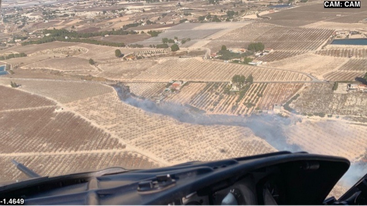 El helicóptero trabaja en un incendio de matorral en una rambla de Cieza