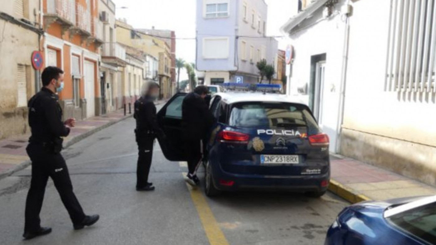 Los agentes introducen en el coche a uno de los detenidos en Alcantarilla. Policía Nacional