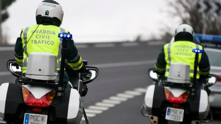 Dos agentes circulan en motocicleta tras un vehículo oficial (archivo). GUARDIA CIVIL