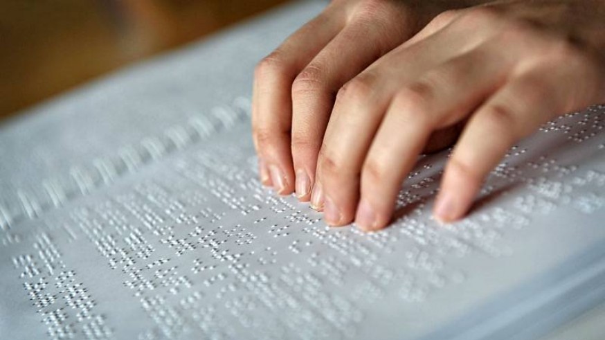 Manos leyendo libro en braille