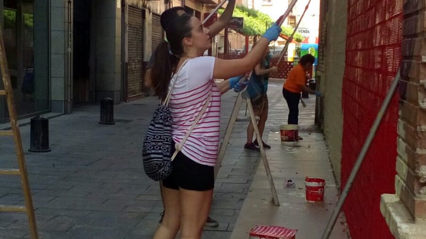 Voluntarios pintan y decoran 50 fachadas y persianas de comercios del barrio de Santa Eulalia