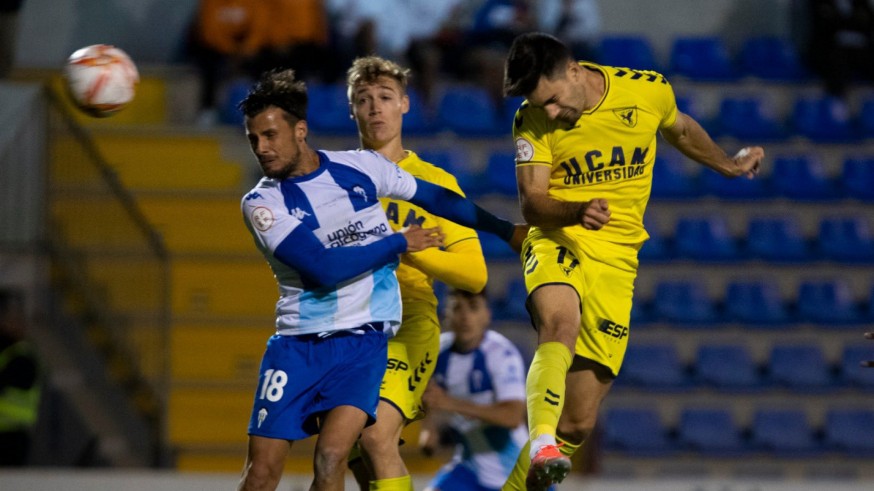 Xemi Fernández cabecea el balón ante la mirada de Manu Garrido