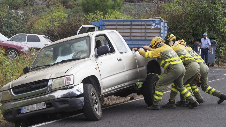 Bomberos ayudan a reincorporar un vehículo a la carretera tras la erupción del volcán