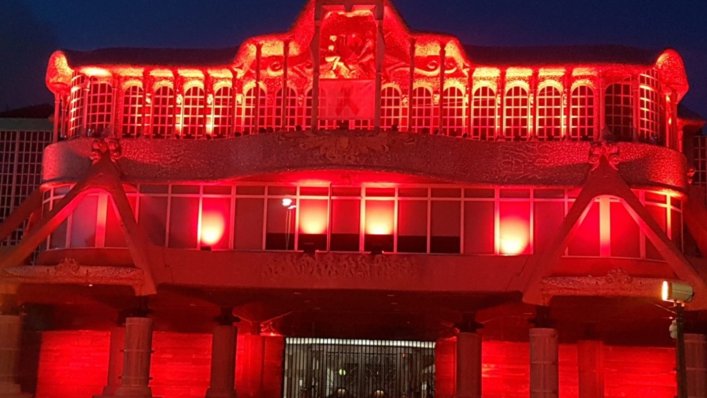 fachada de la asamblea iluminada de rojo