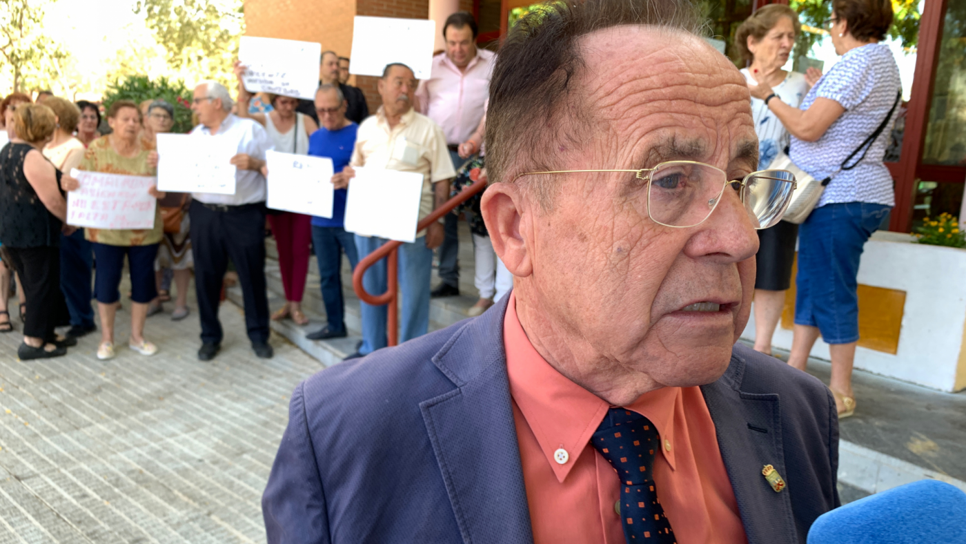 El pedáneo de Churra, Ángel Lorca, hace declaraciones a los medios con los vecinos protestando detrás. ASR