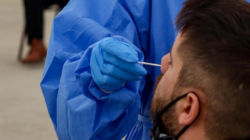 Una sanitaria realiza una prueba PCR a un joven
