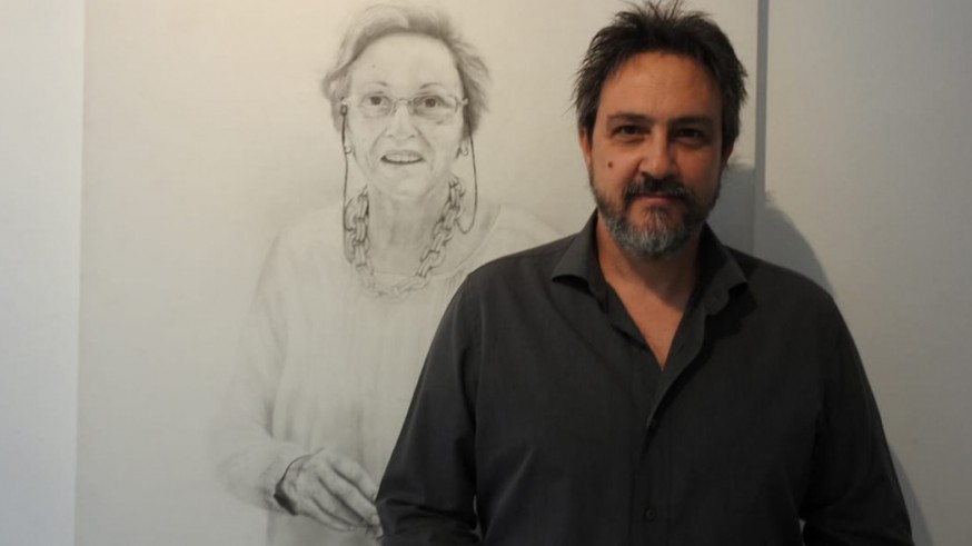 Antonio Tapia junto al retrato de su madre en la exposición "Cautivas"