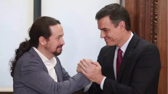 Pablo Iglesias y Pedro Sánchez estrechándose las manos tras alcanzar un acuerdo de gobierno