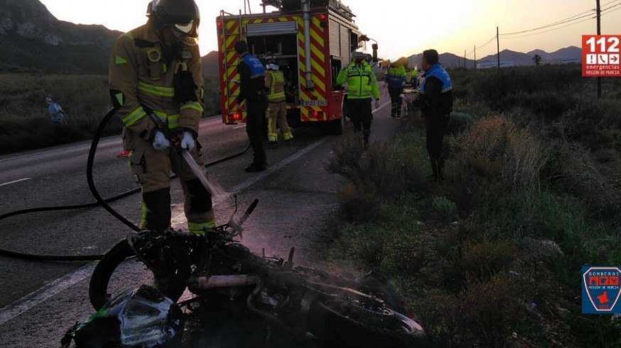 Los bomberos apagan el fuego en la moto accidentada. CEIS.