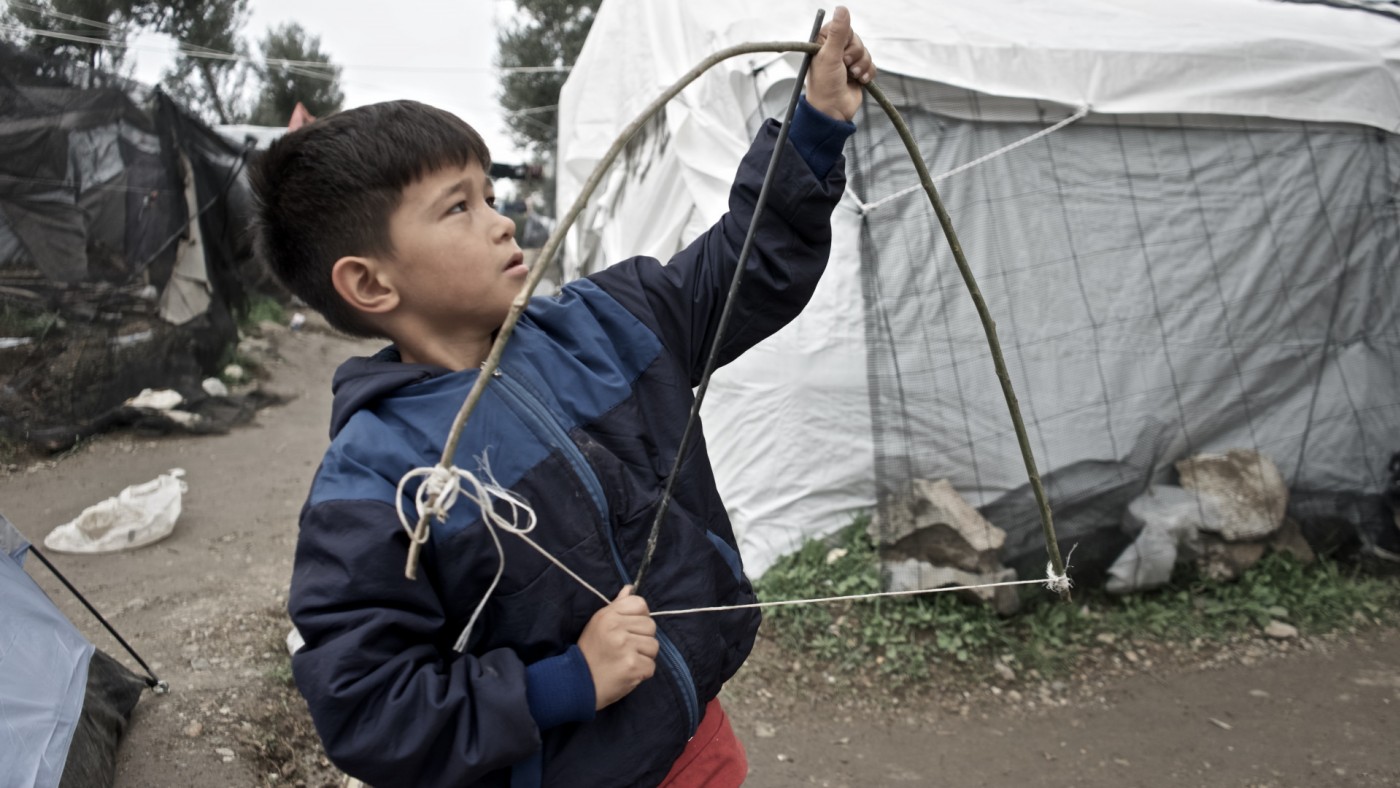 Niño se fabrica un arco para jugar en un campo de refugiados de Lesbos. Foto: Paloma Comuñas
