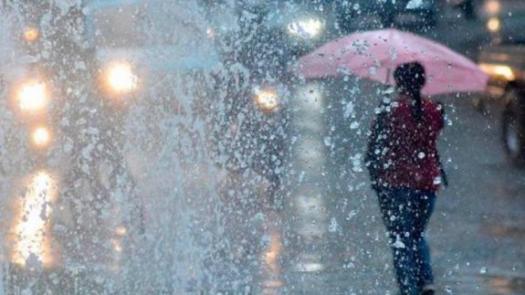 Una mujer caminando bajo la lluvia. SALUD180