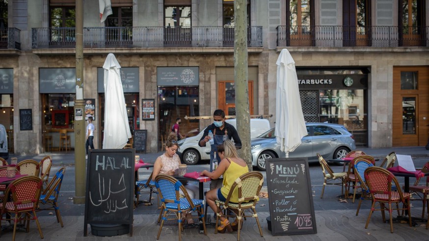 Dos mujeres comen en la terraza de un bar en Barcelona