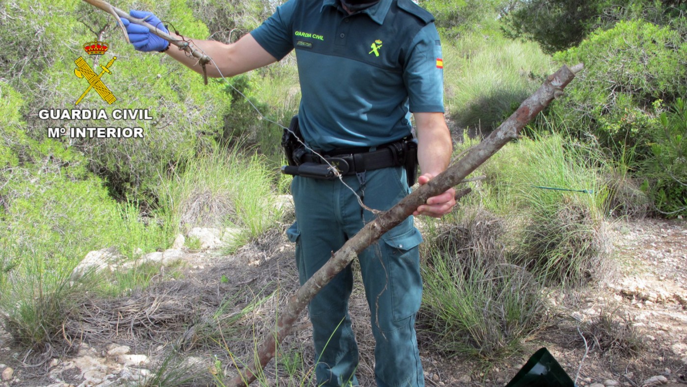 Una agente muestra el hallazgo de un lazo artesanal elaborado con cable de acero. G. CIVIL