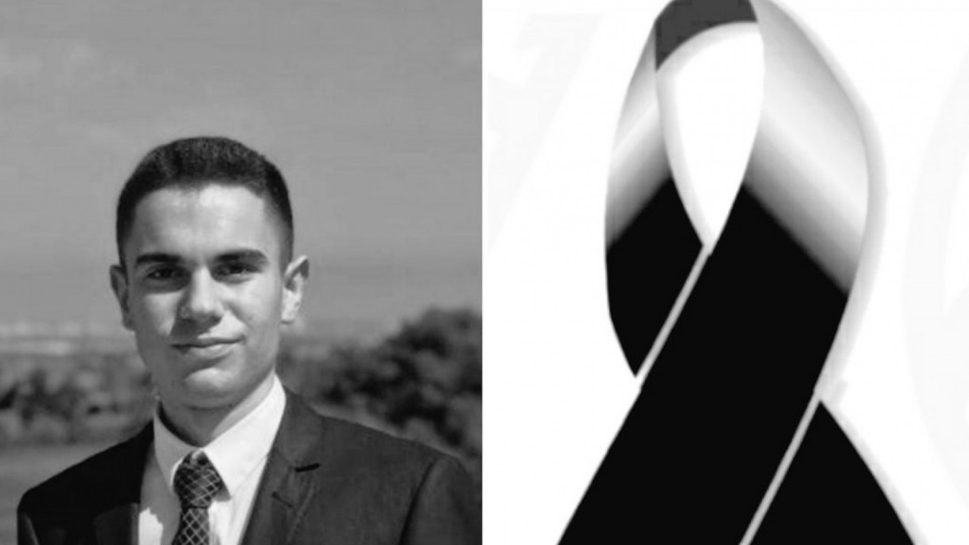 Imagen del joven asistente junto a un lazo negro