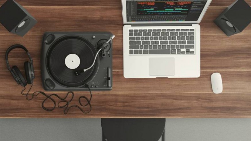 Tocadiscos, ordenador, altavoces y auriculares sobre mesa