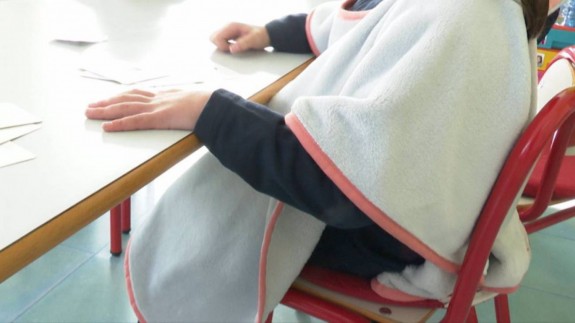 Un alumno con una manta en el aula. EUROPA PRESS