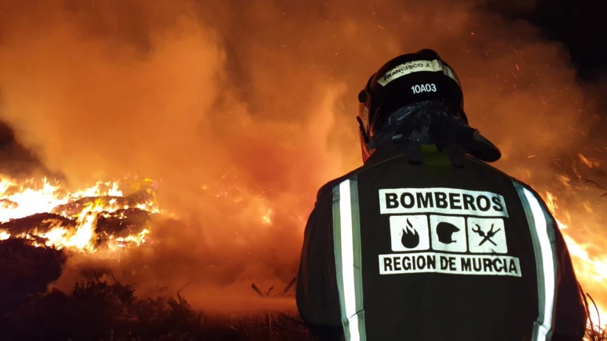 bombero sofocando el fuego en la planta de reciclaje