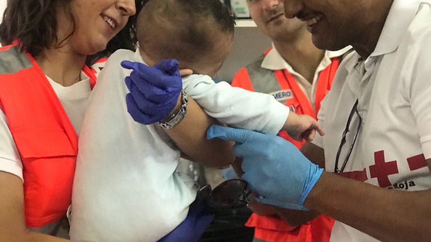 El equipo de Cruz Roja atiende a uno de los bebés que viajaban en una de las pateras