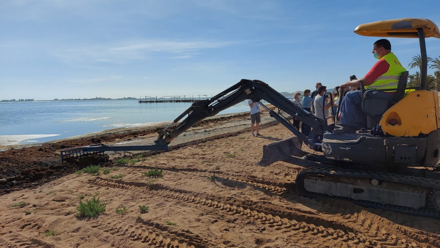 Excavadora retirando fangos de la playa de Estrella de Mar