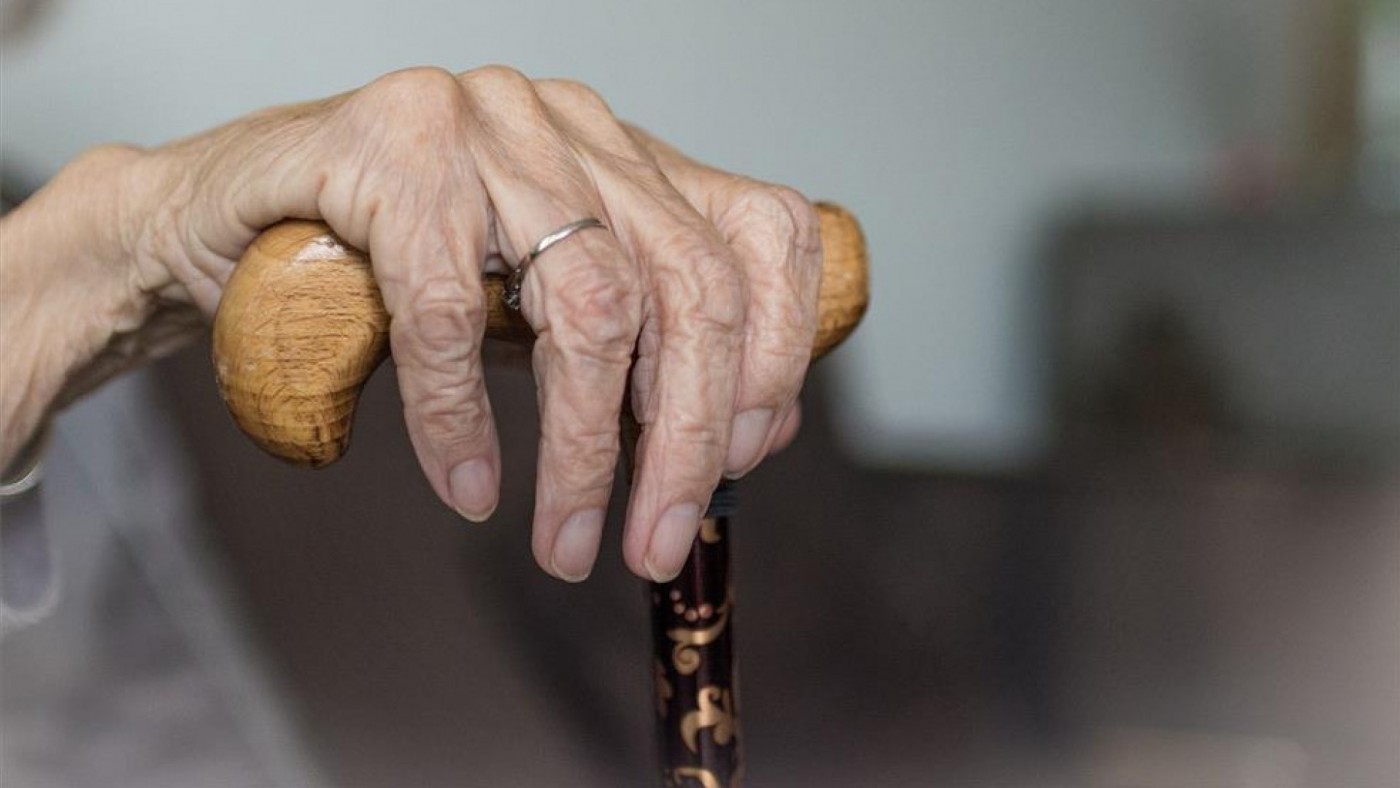 Una mujer mayor sostiene un bastón