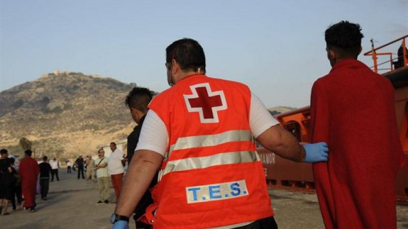 Un trabajador de Cruz Roja ayudando a un inmigrante. EP