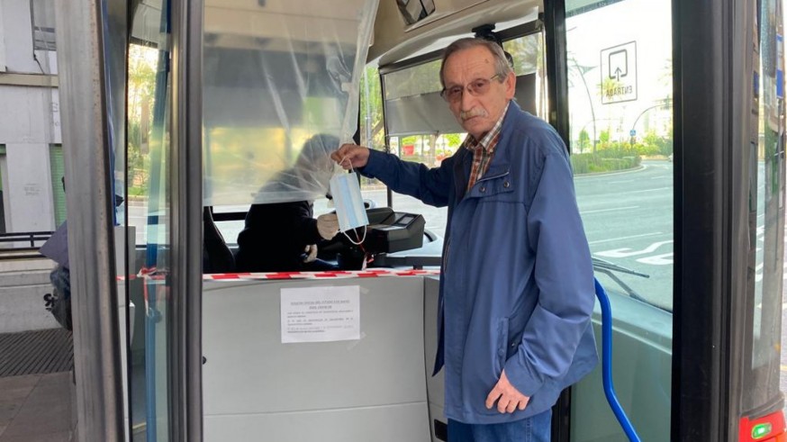 Un viajero recibe una mascarilla al subir al autobús en Murcia