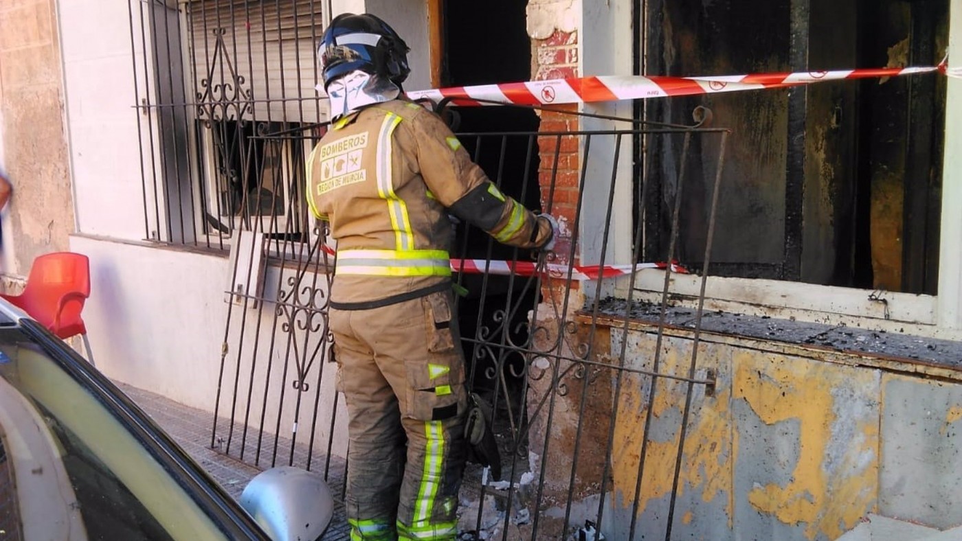 Un bombero en la puerta de la vivienda que ha sufrido el incendio - CEIS RM