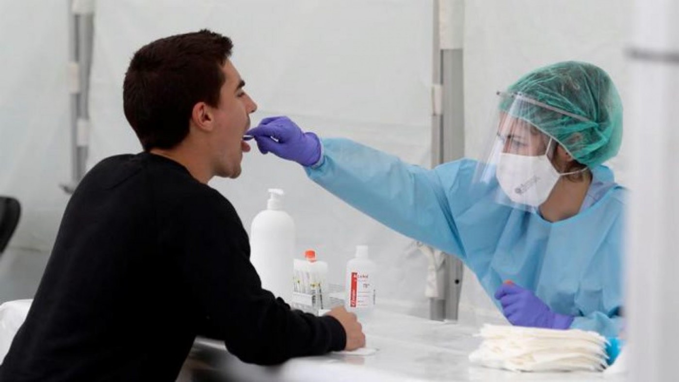 Una sanitaria le realiza un frotis bucal a un joven. EUROPA PRESS
