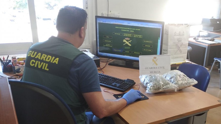 Agente de la Guardia Civil junto a la droga incautada