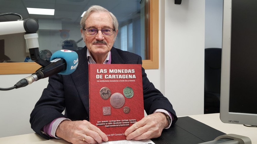 El escritor José María Conesa con su libro sobre numismática cartagenera