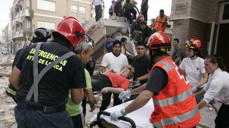 Bomberos y sanitarios atienden a una mujer rescatada de la ruinas de un edificio. JUAN CABALLERO