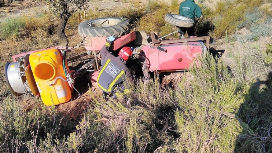 Bomberos y Guardia Civil junto al tractor accidentado
