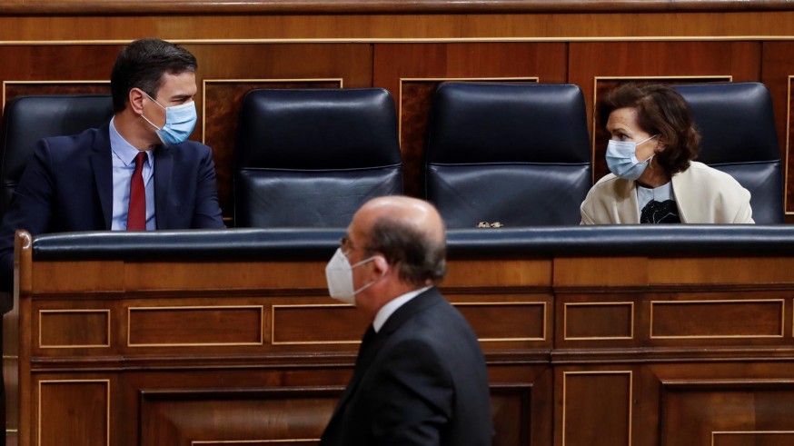 Sánchez y Carmen Calvo, ambos con mascarilla, conversan antes del pleno 